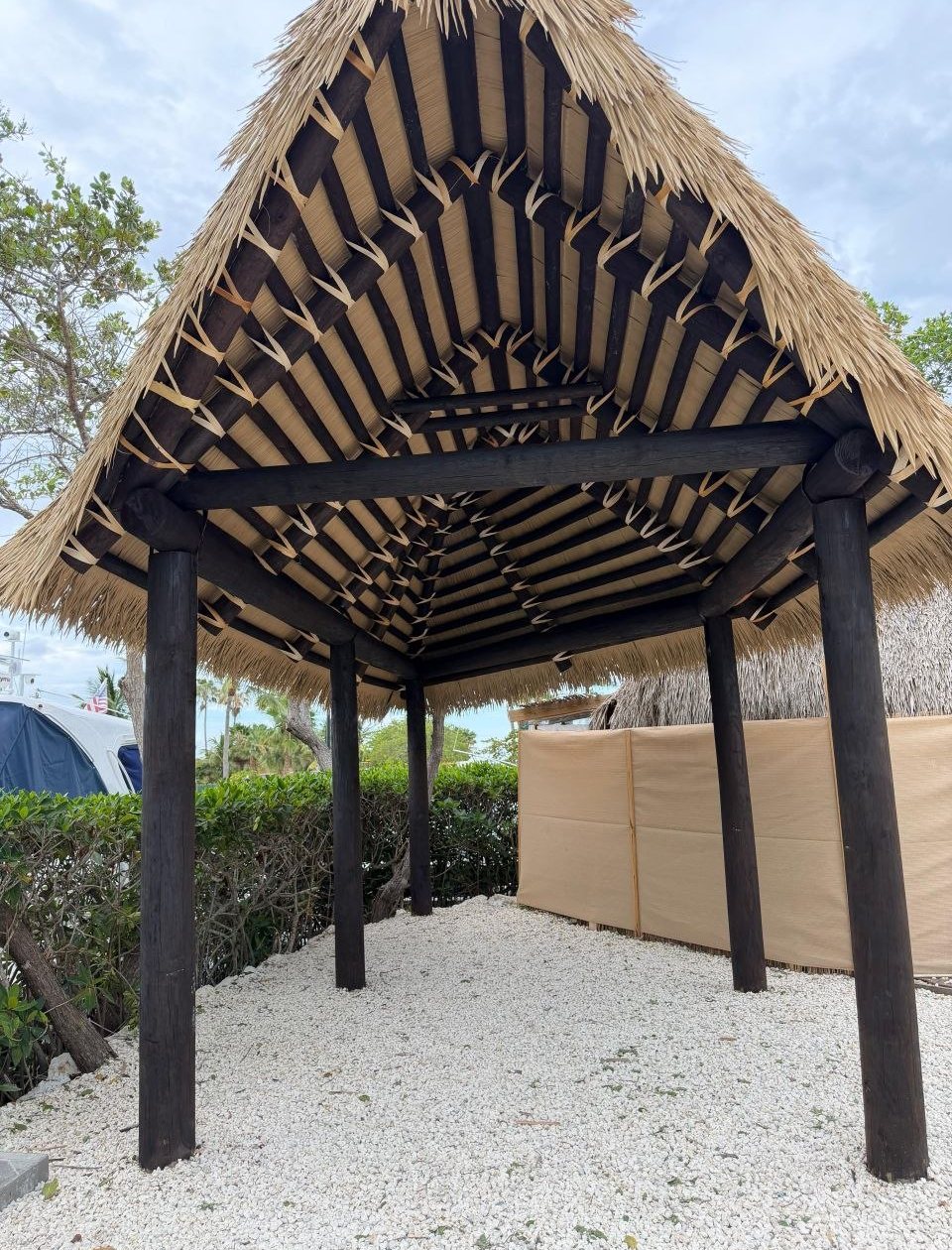Looking up into the cypress frame and thatch of a new tiki hut